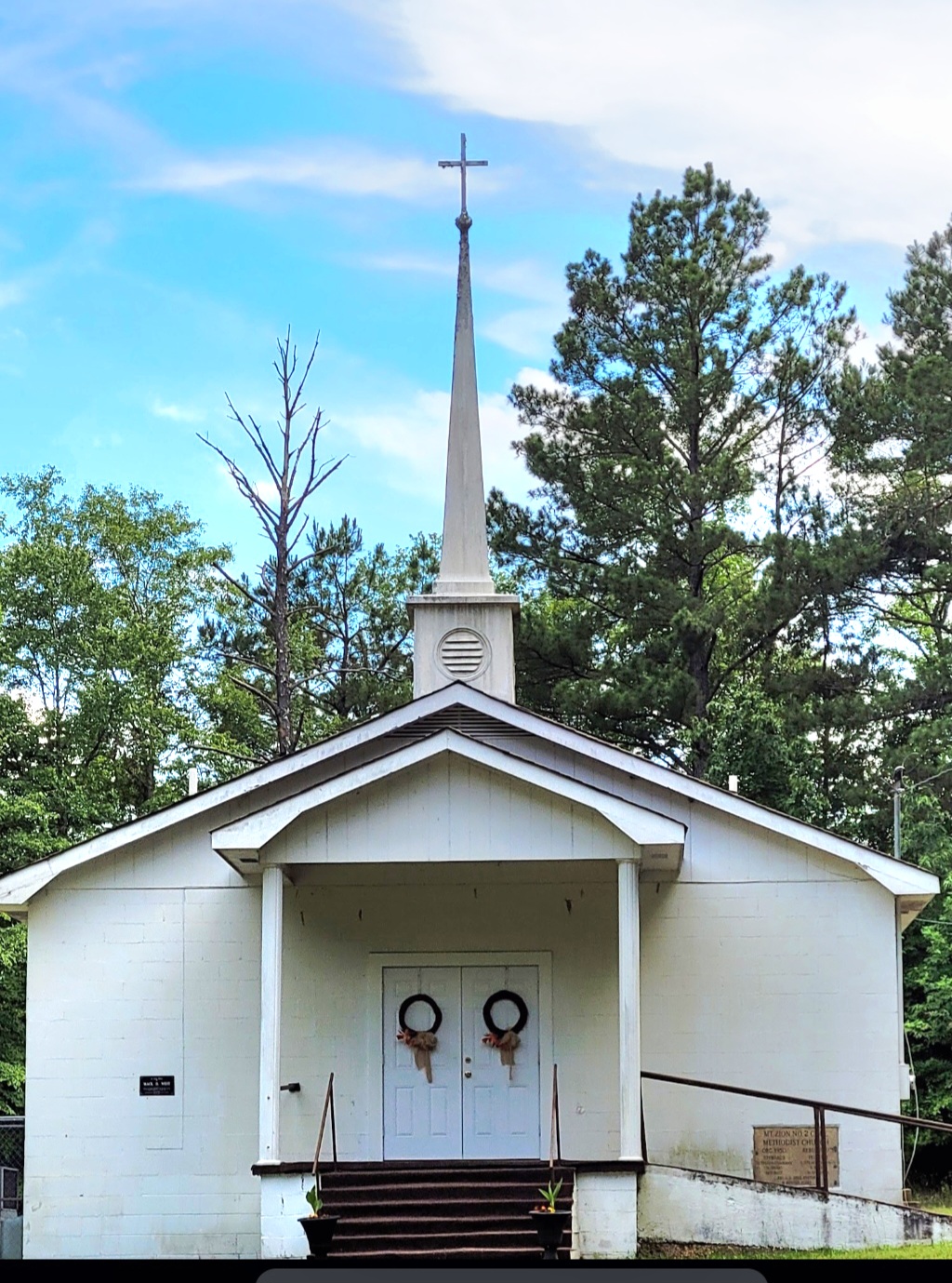 Church front with steeple attached.